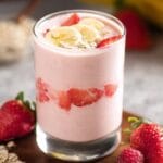 Greek yogurt smoothie in tall glass with fruit and oats