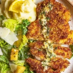 Appetizing Crunchy Parmesan Chicken meal with mashed potatoes and Caesar salad.